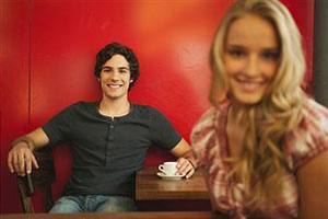 Мужчина смотрит на девушку в кафе