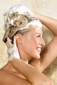Женщина моет голову шампунем